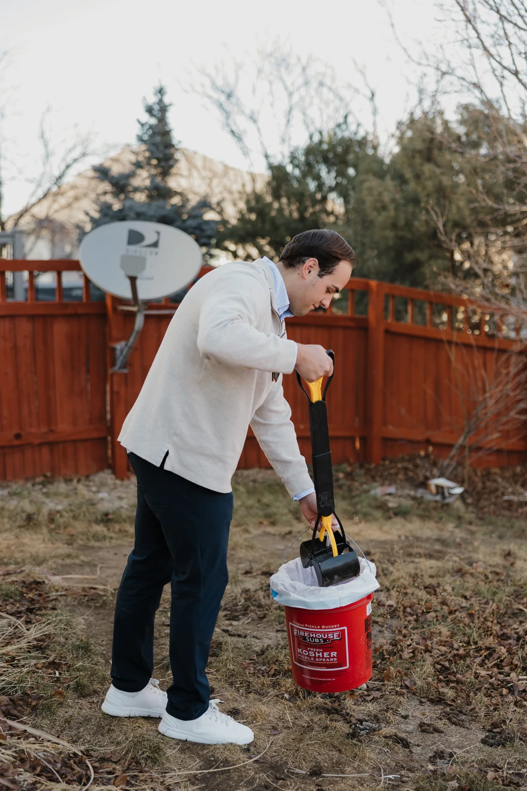 A Prevail team member carefully scooping a Colorado backyard